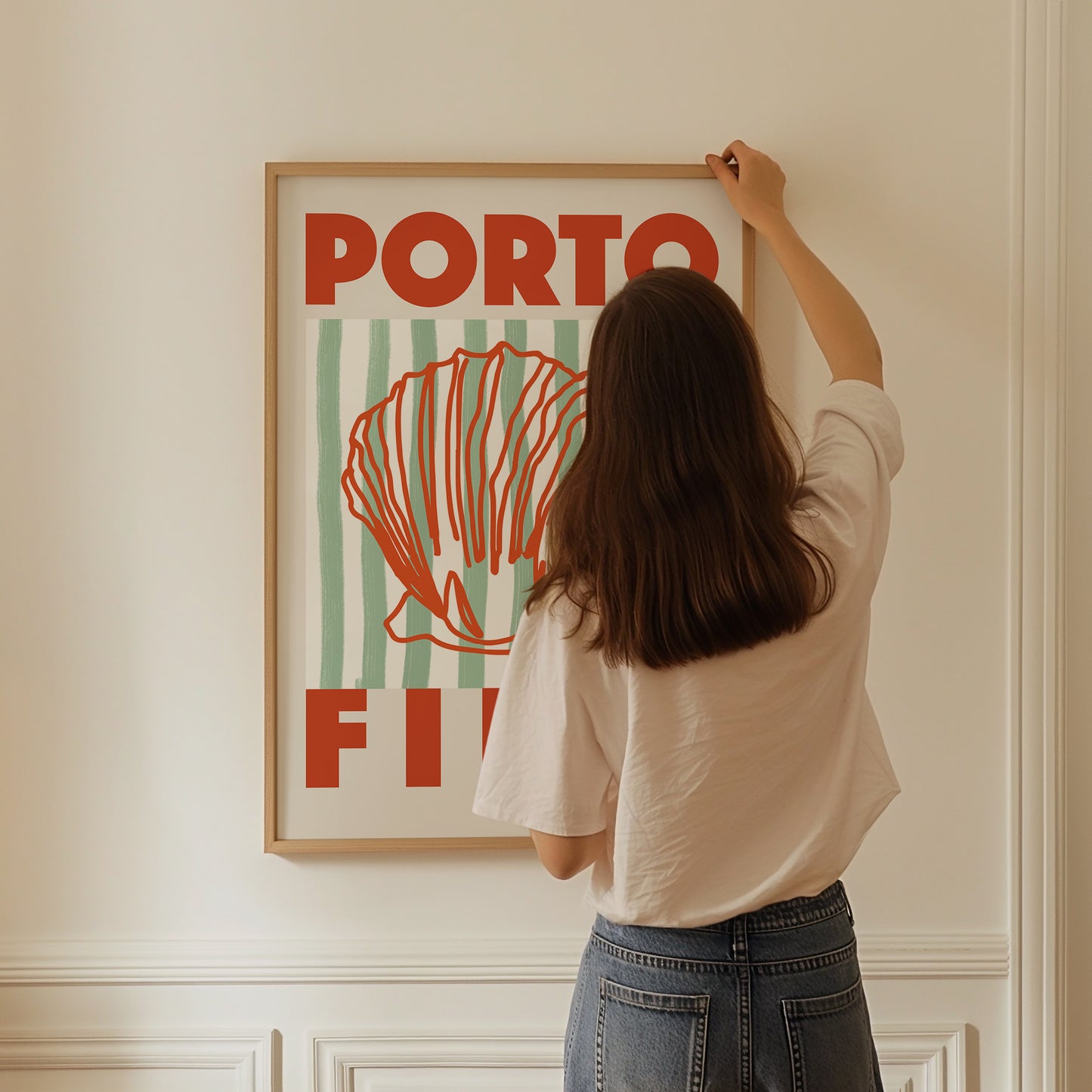 a woman hanging a poster on a wall