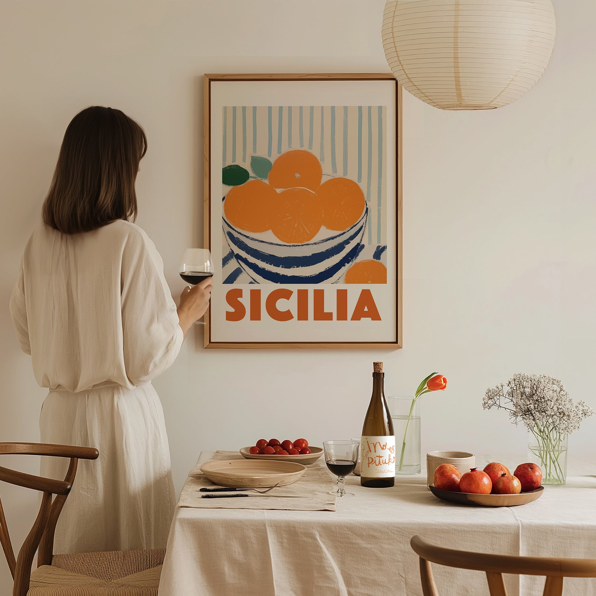 a woman holding a glass of wine in front of a poster