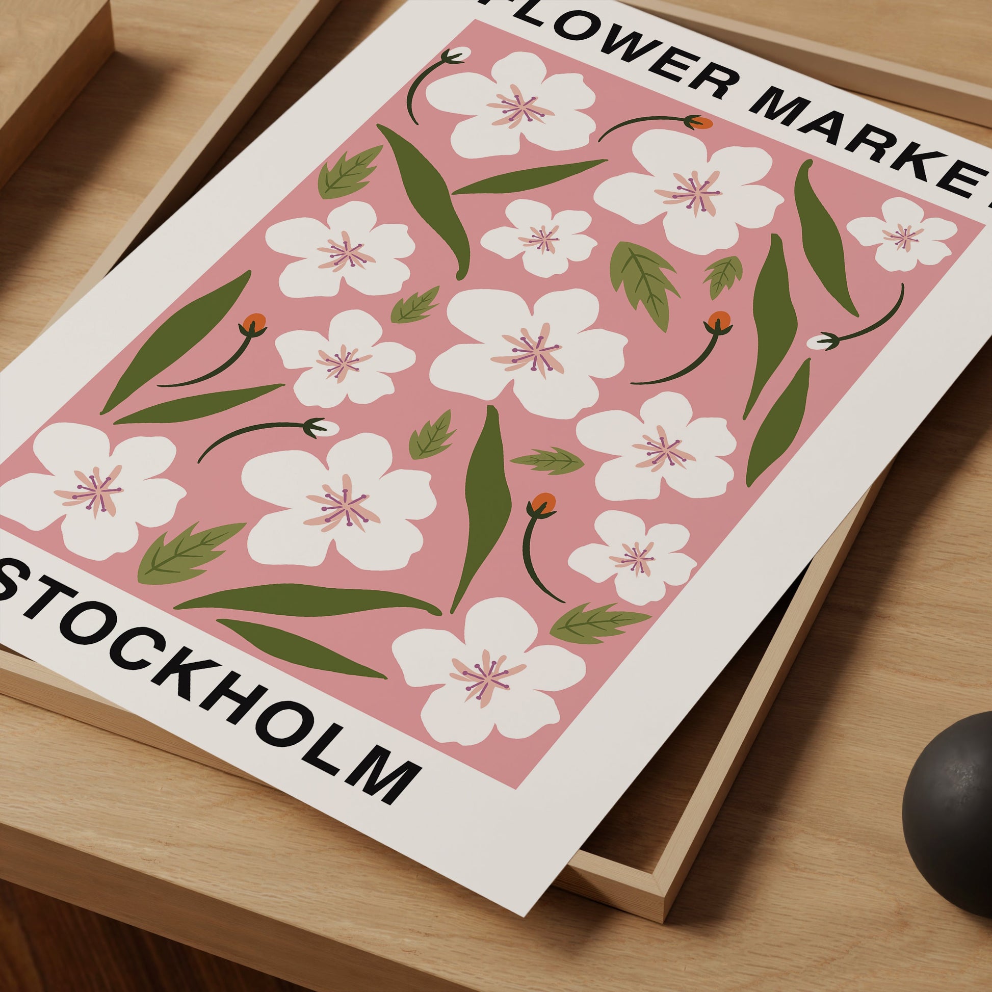 a flower make stockholm poster on a desk next to a computer mouse