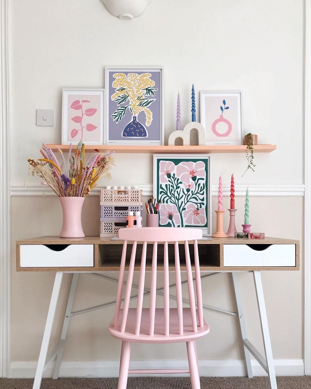 a desk with a pink chair next to it