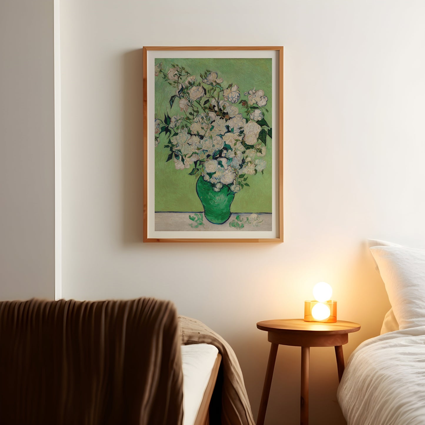 a picture of a vase of flowers on a wall above a bed