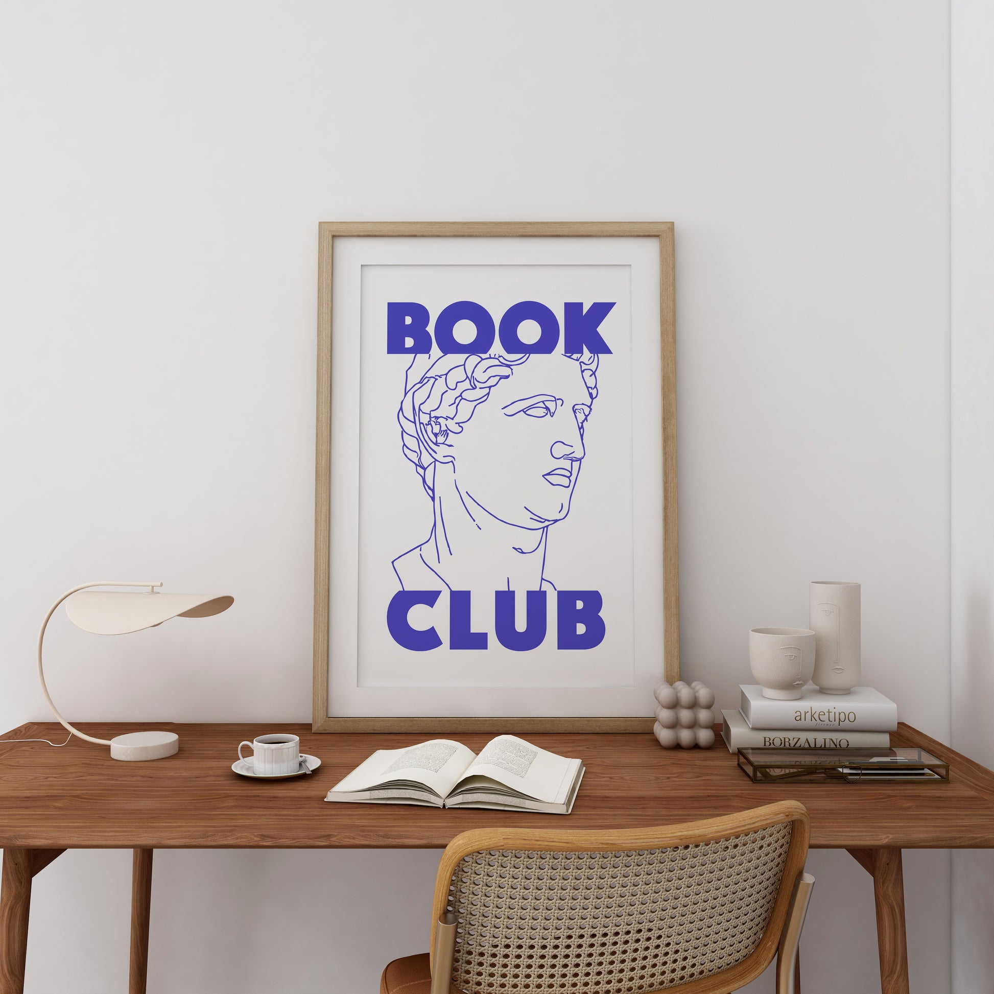 a framed book club poster on a desk