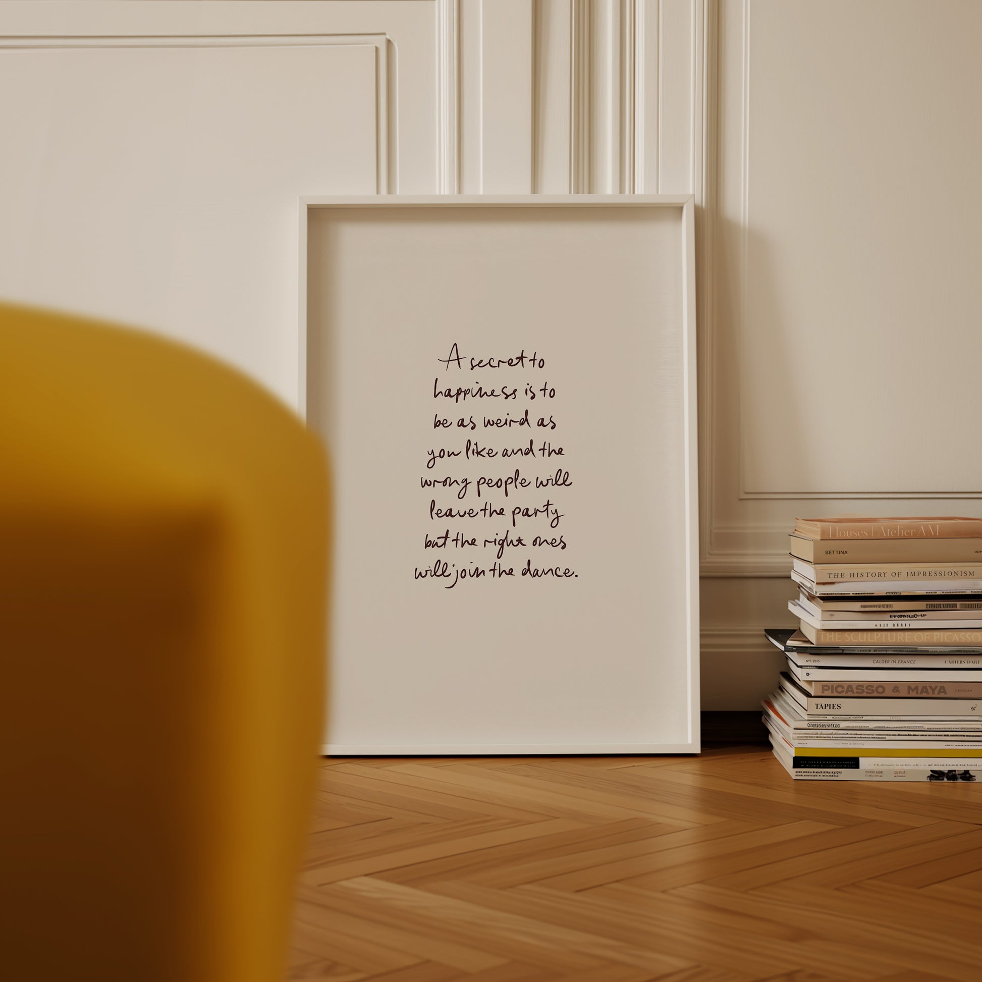 a picture frame sitting on a wooden floor next to a stack of books