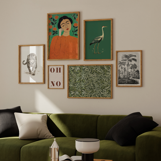 a living room with a green couch and pictures on the wall