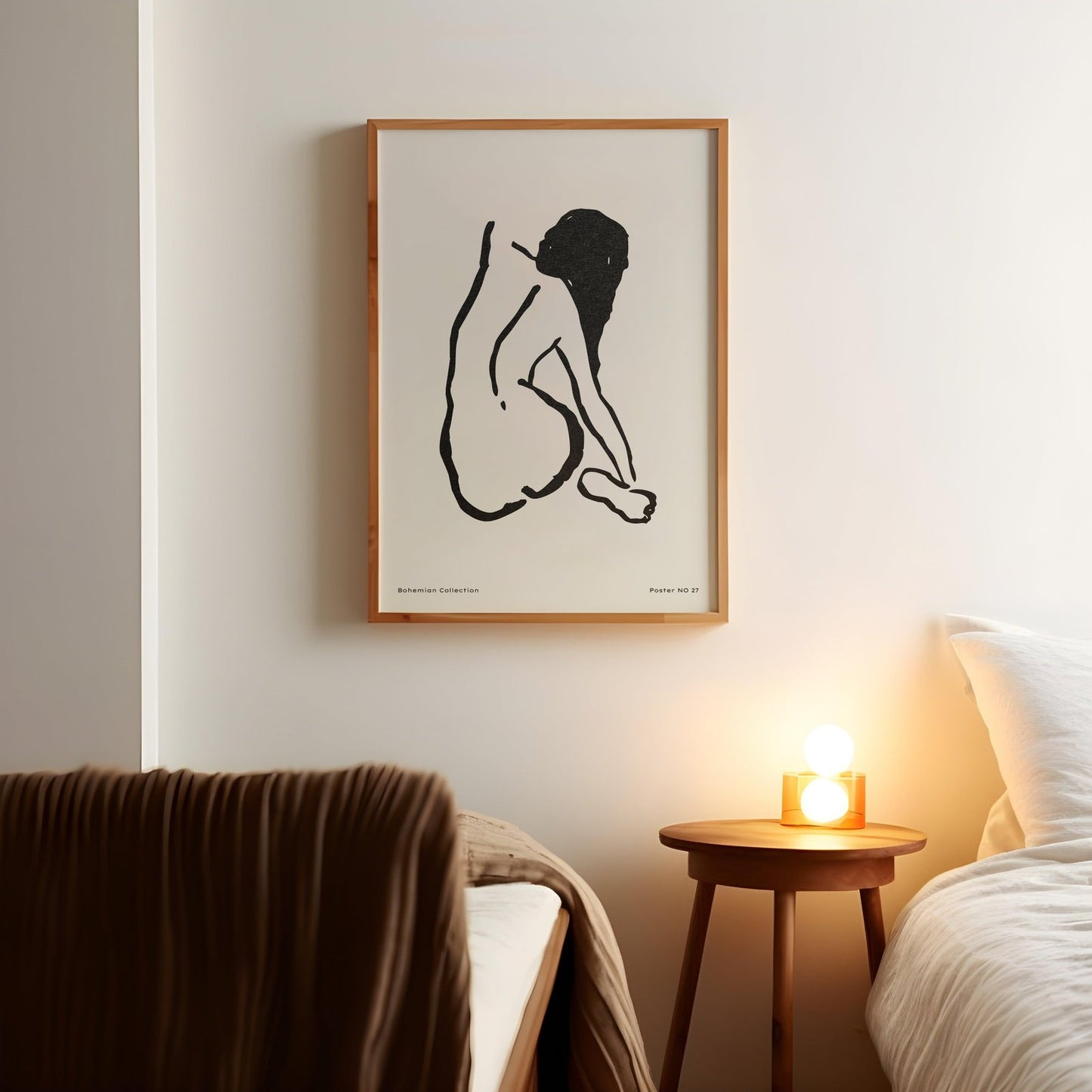 a picture of a naked woman on a wall above a bed