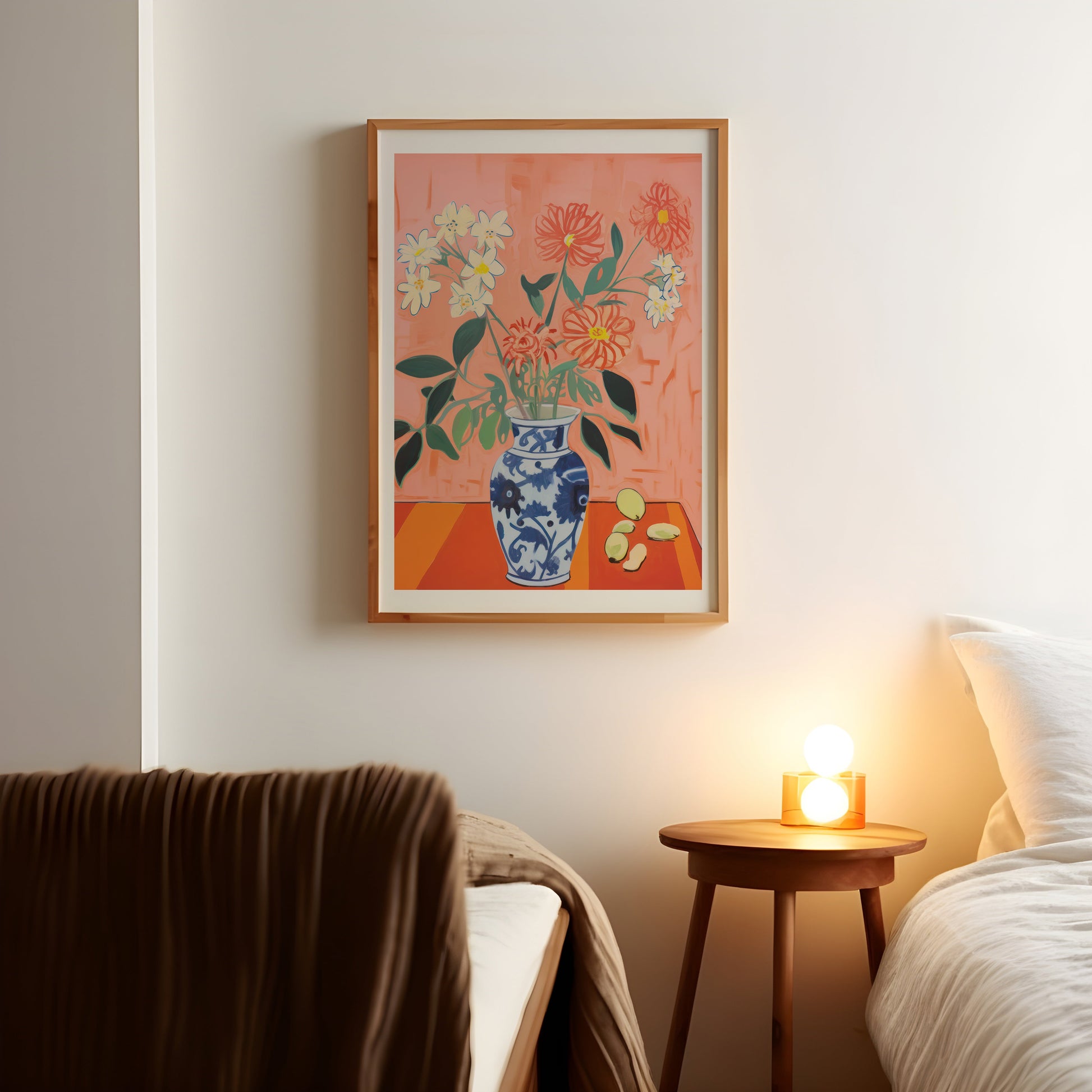 a picture of a vase of flowers on a wall above a bed